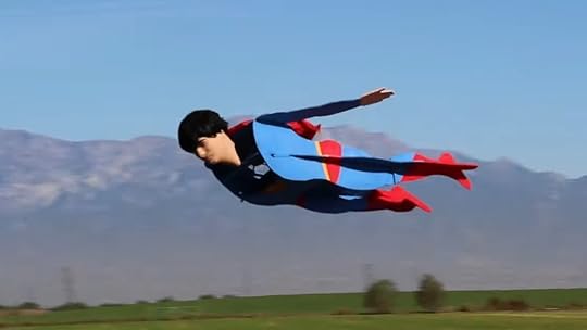 A remote-controlled Superman in his blue and red suit flying in the sky