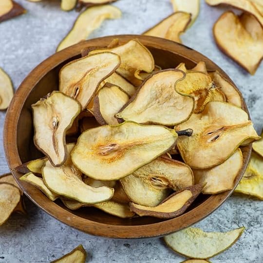 Dehydrated pear slices in a wooden bowl.