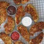 chicken strips on wire rack with sauce cups.