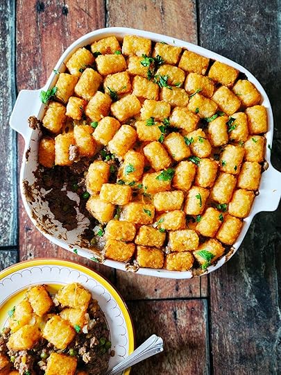 A casserole dish of tater tot hotdish with a plate of the meal alongside.