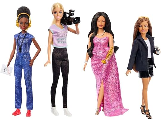 Four different Barbie dolls with accessories on display from Mattel's Women in Film collection