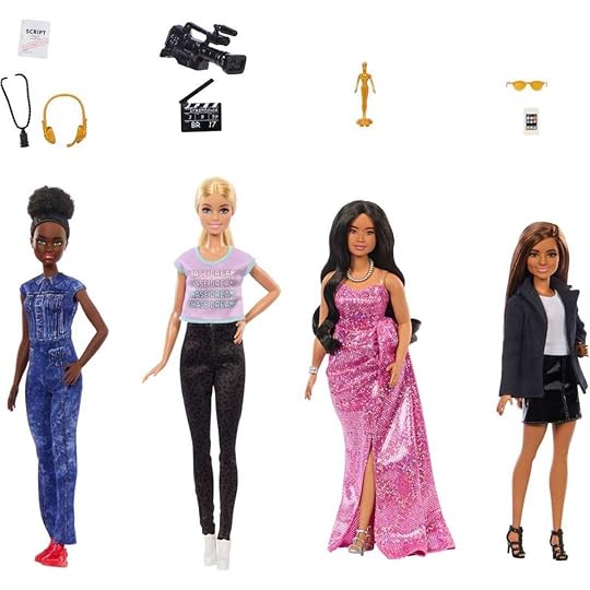 Four different Barbie dolls with accessories floating above their heads on display from Mattel's Women in Film collection