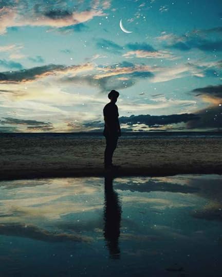 silhouette of man standing near body of water