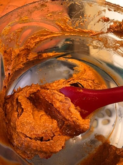 red sauce in a food processor with a red spatula/rubber scraper in it.