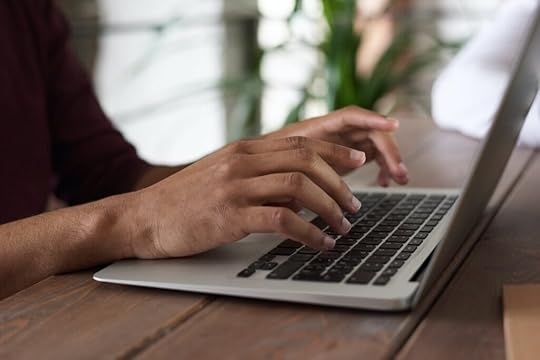 A person typing a story on a computer.