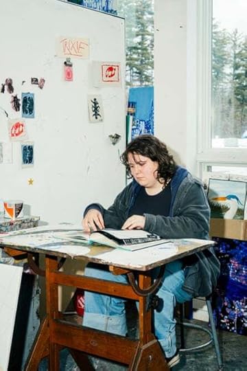 A student flips through a book at the Arts studio at Buxton School, Williamstown, MA.