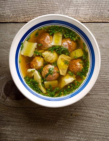 A bowl of artichoke soup on an old wooden table.