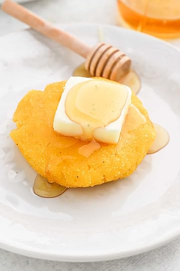 Delicious hot water cornbread next to a bowl of mustard greens
