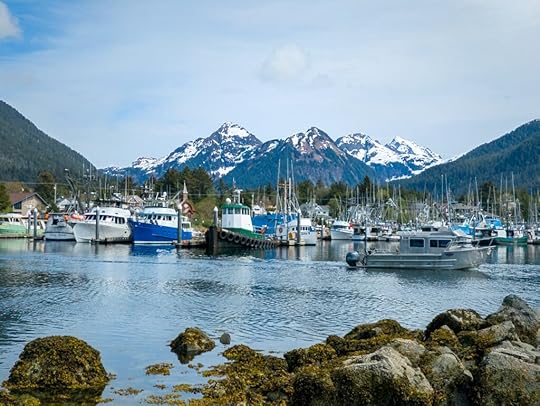 Snow capped mountains in Alaska with boats in a boat harbor
