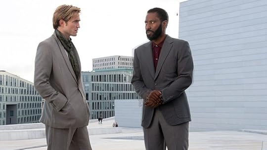 Two men stand on top of a city building talking