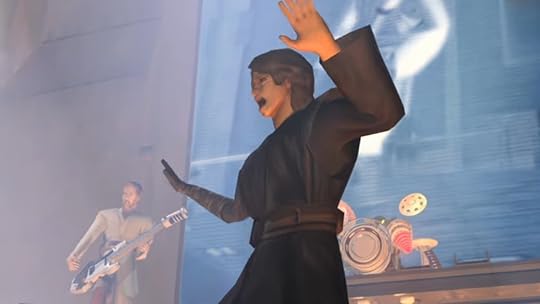 A video game Anakin sings while Obi-Wan Kenobi plays guitar in the background on stage