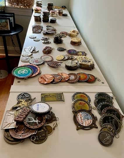 A lot of medals spread out along the top of a shelf.