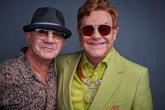 Recent color photo in a studio; both men are wearing glasses and smiling at the camera.