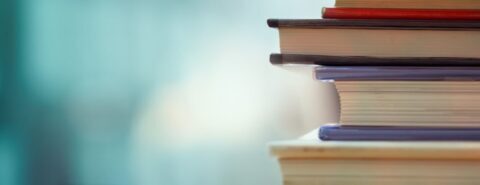 Stack of books against a blue background.