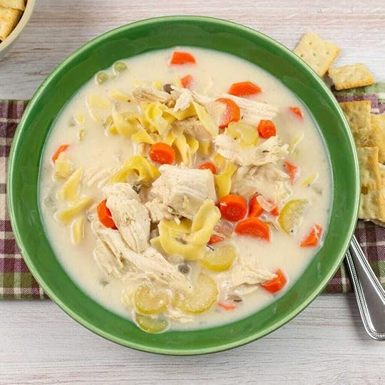 Crock Pot Creamy Chicken Noodle Soup served in a green glass bowl with saltine crackers.