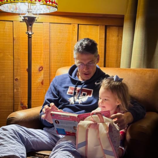 Peter and young niece sit in a chair reading a kids' book
