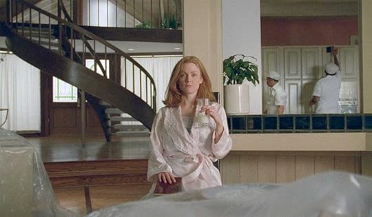 Julianne Moore in a pink bathrobe holds a glass of milk in Todd Hayne's
