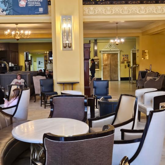 Inside the lobby of the Arlington Hotel with its chandeliers and golden elevator doors.