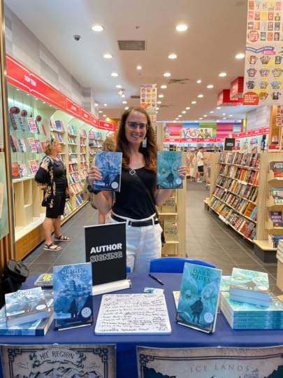 Sarah Kate Ishii holding up two of her books from the Dynasty Codes fantasy series at a book signing with Dymocks, Australia.
