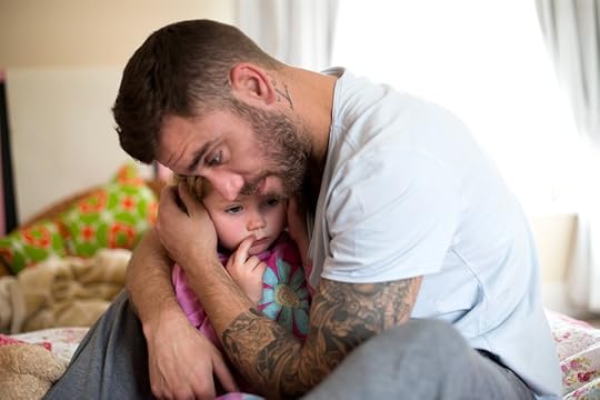 Father with a beard and tattoos comforting his toddler daughter
