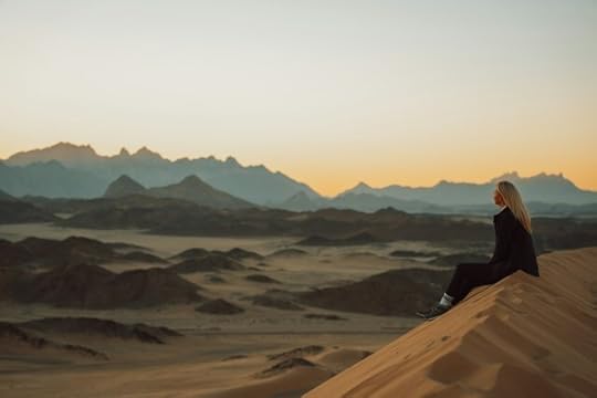 Woman sitting on a sand dune in the desert. To Live Life, If Not Today, When?