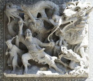 Image of a stone sculpture of an ancient hero fighting a dragon