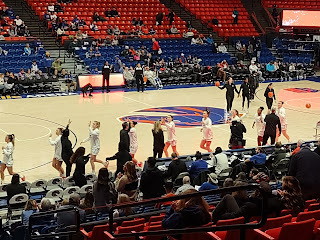 Boise State women's basketball home game where players are giving high fives to coaches while heading to the bench