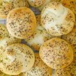 closeup of everything hamburger buns piled on a cooling rack.