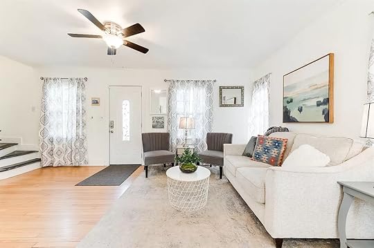 a living room with a white couch and a white table