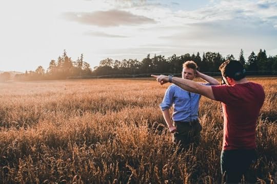 Two men in a field, debating their approach?