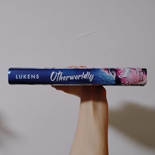 Photo of the spine of Otherworldly by FT Lukens. Deep blue background with white text, and a little image of the characters from the cover near the bottom.