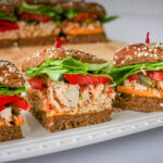 close up of pulled chicken sliders on a serving tray.