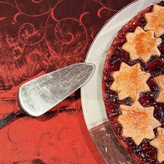 Festlich aussehender Kuchen auf einem Teller auf dunkelroter Tischdecke
