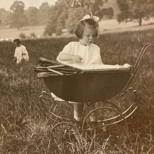 A Child ( the author's mum) iin a field in the 1920s with a toy pram