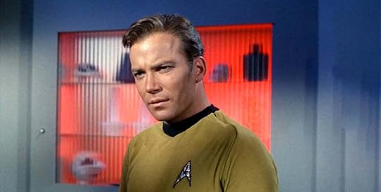 Captain Kirk looking stern and pensive, against a red glowing cabinet