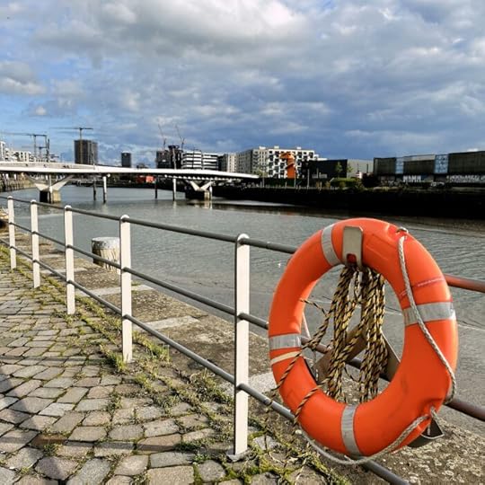 Blick auf die Neubebauung am Baakenhafen, im Vordergrund ein Rettungsring am Geländer des Weges neben dem Elbeseitenarm