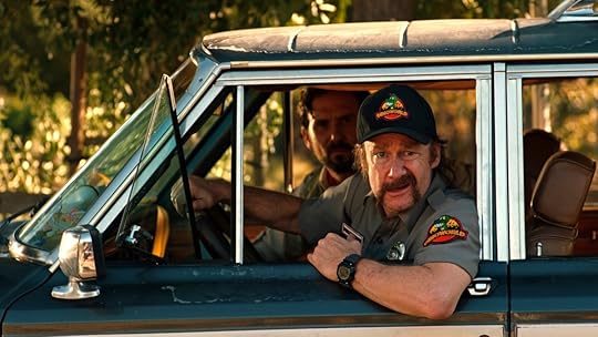 A security guard hanging out his car window in The Invisible Raptor