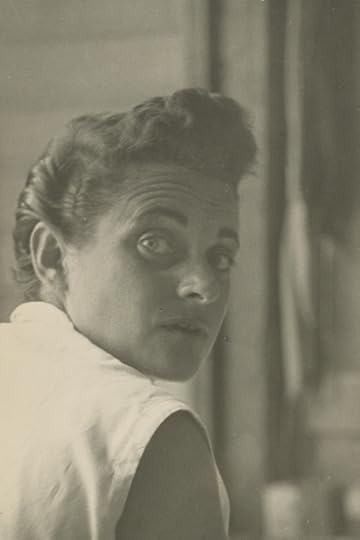 Head-and shoulders shot of Klotz turned to look back over her right shoulder. She's wearing a white sleeveless top and her hair is pulled back. 