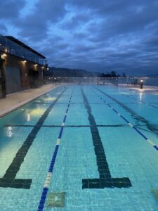 Outdoor pool lit up under cloudy sky