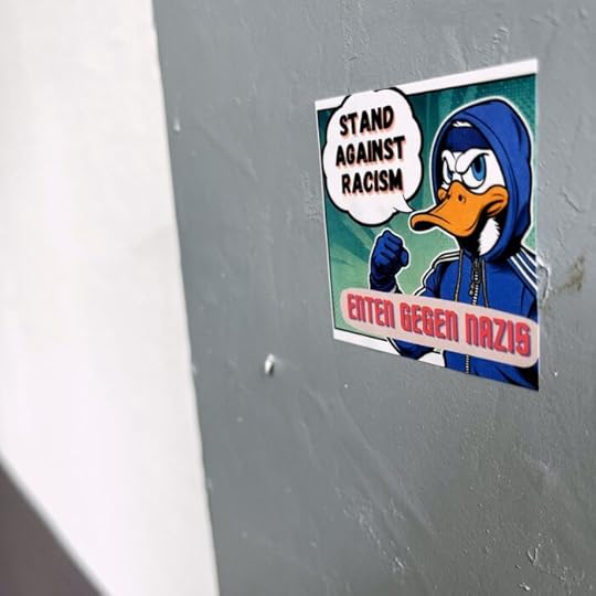 Ein Sticker an einer Wand, darauf eine Ente im Disney-Stil, wie Donald, mit Sprechblase: 
