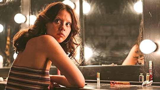 Mia Goth as Maxine sits at a vanity table looking backwards in MaXXXine