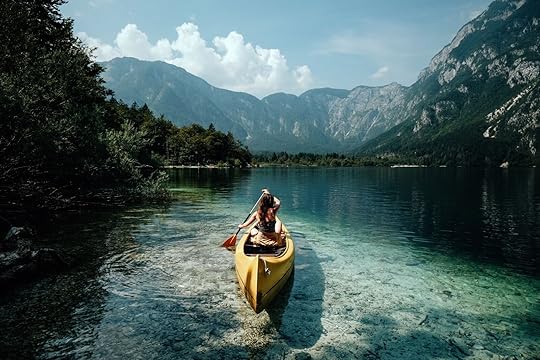 Young woman canoeing in the lake bohinj on a summer day one of the best lakes in Europe