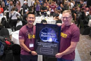 Gym owner Chris Plentus receives an award for $1 million net worth from Two-Brain Founder Chris Cooper.