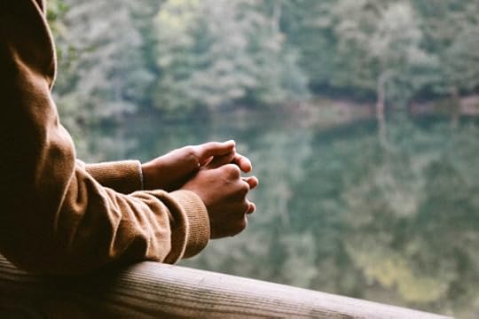 forearms on a railing, person thinking. language