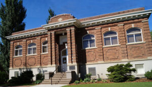 Lovely old two-storey red brick building silhouetted against a brilliant blue sky.