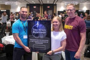 Leighton and Joleen Bingham receive an award for $1 million net worth from Two-Brain founder Chris Cooper.