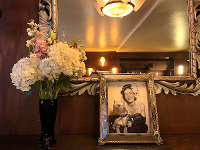 Photo pf Billy Holiday on mantel with white flowers.