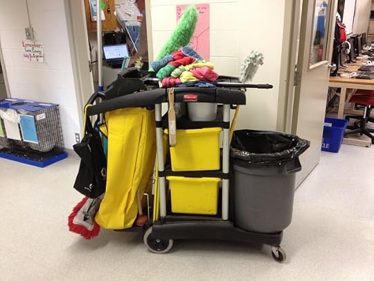 yellow janitor's car with garbage bins and multi-colored cleaning supplies in front of open, messy offices