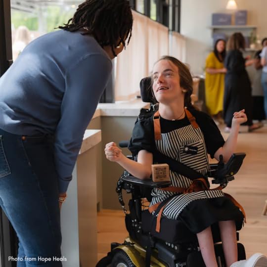 hoto of a Mend Coffee employee using a wheelchair talking to a customer