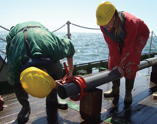 Gerard Versteegh and Karin Zonneveld, coauthors of the new study on climate change and pandemics, process a sediment core from the Gulf of Taranto. (Courtesy of Karin Zonneveld.)